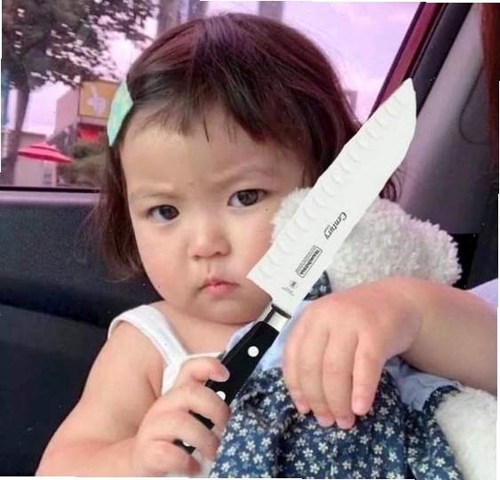 Meme em bé cầm đồ vật như dao đe dọa với vẻ mặt tinh nghịch