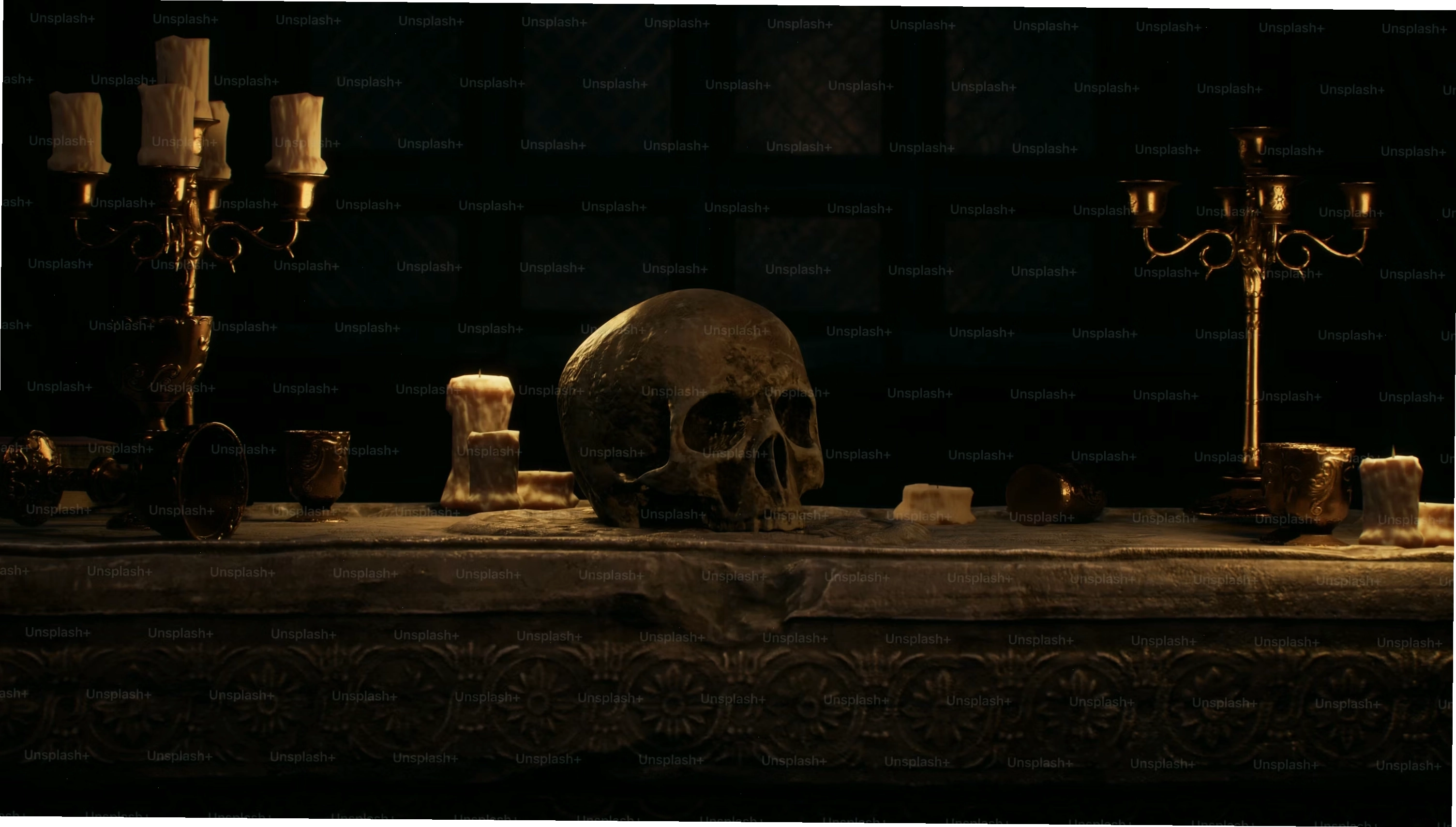 A skull sitting on top of a table next to candles